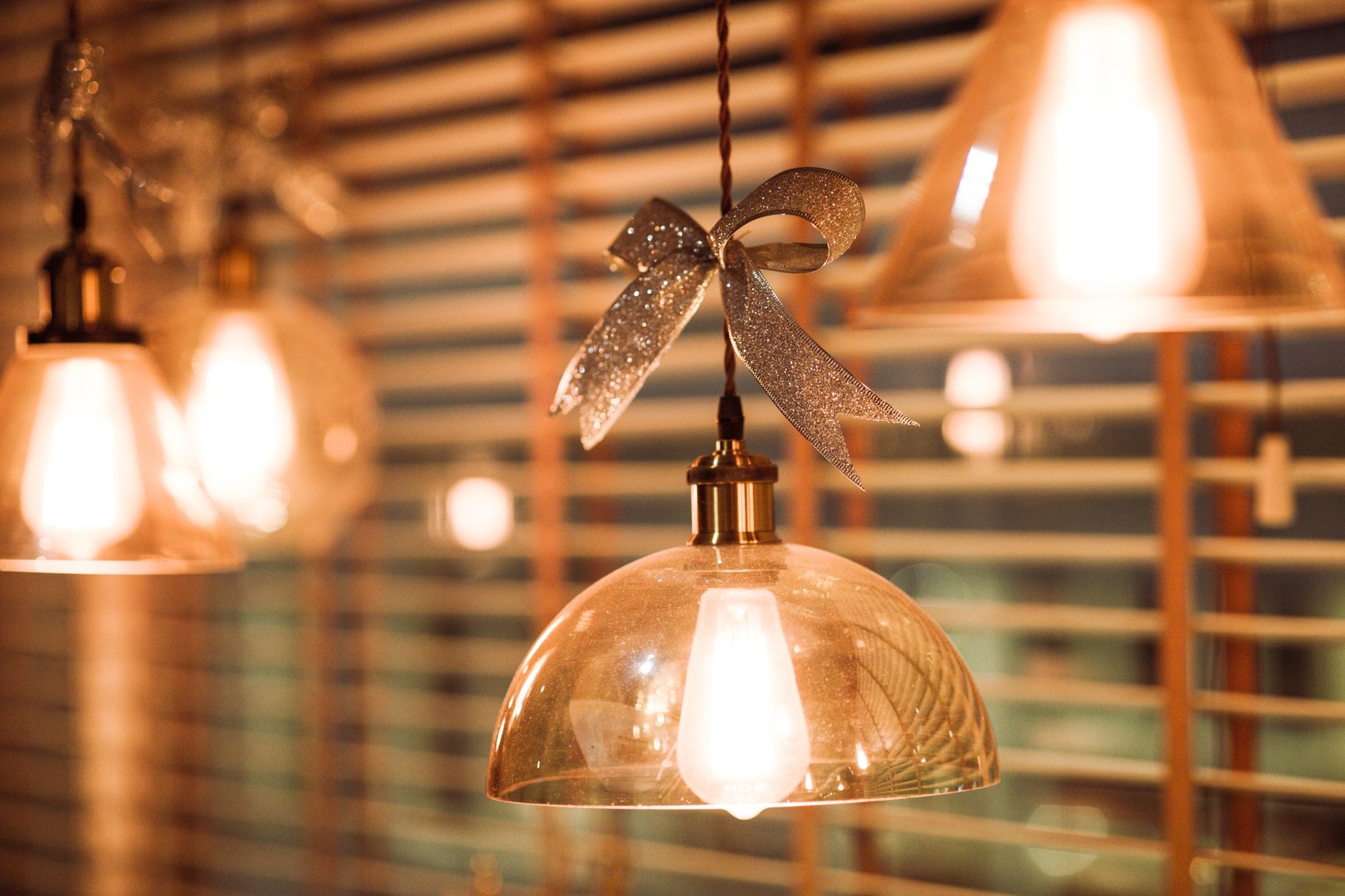 Warm pendant lights with a festive bow, creating a cozy indoor atmosphere. Perfect for holiday decor.