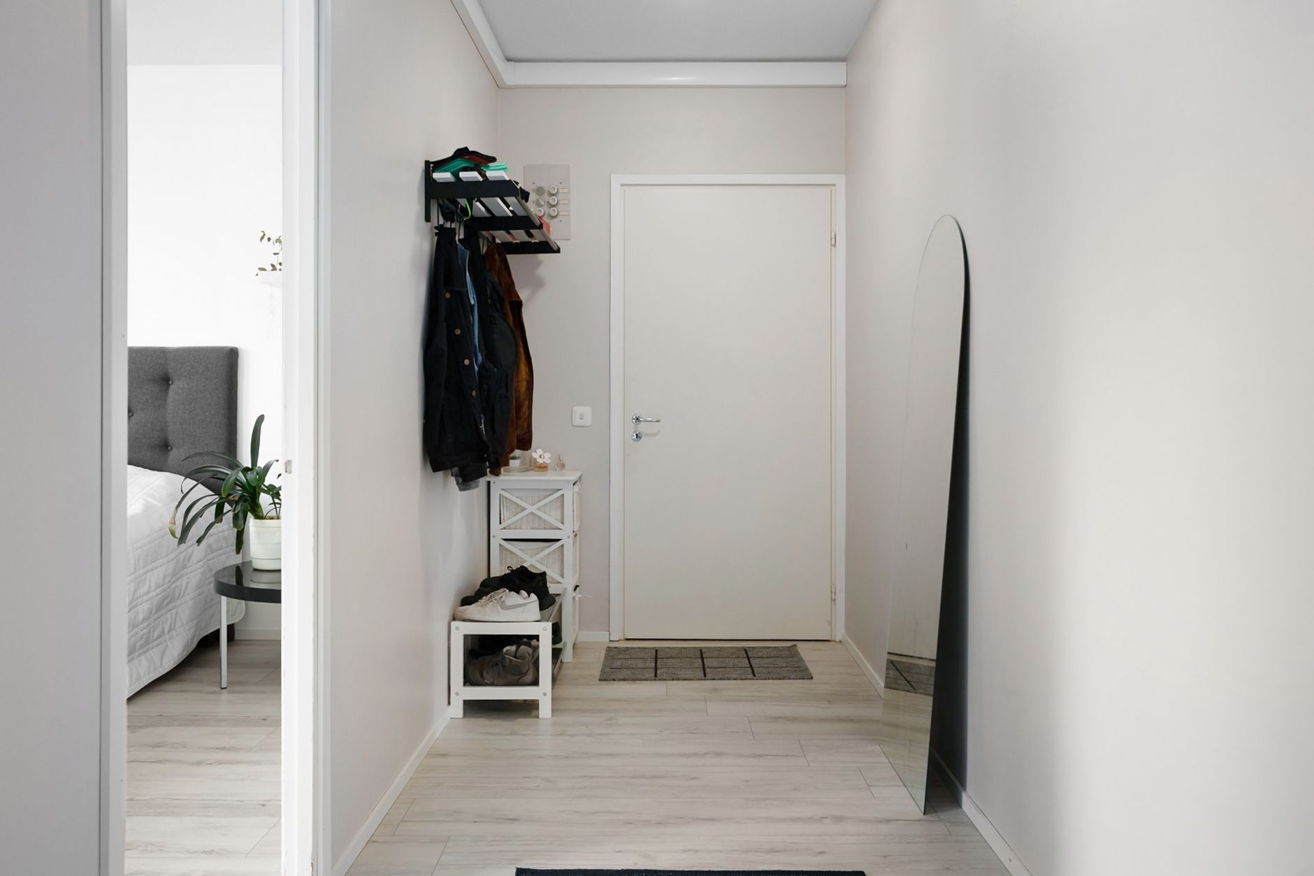 A minimalist hallway with white walls, modern decor, and simple furnishings.